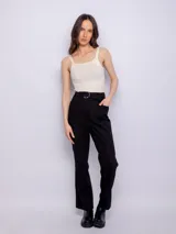 Pantalón negro de algodón con corte recto y tiro alto, cierre frontal con hebilla metálica plateada y bolsillos laterales.