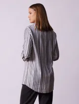 Camisa de lino a rayas grises, blancas y negras, con cuello clásico, escote en V, abertura frontal con botones y bolsillo de parche en el pecho.