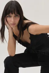 Top negro de lurex con tirantes finos regulables, volados en el frente y lazos en la espalda.