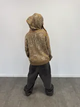 Buzo tipo hoodie con cierre frontal completo, confeccionado en tejido de punto grueso de algodón con diseño gráfico abstracto y tipográfico. Presenta capucha con bordado, puños y ruedo acanalados, y etiqueta de marca en la manga.