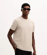 Remera de corte slim en color beige, con cuello redondo, mangas cortas y tejido texturizado que no se arruga.