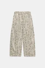 Pantalón estilo pijama de tiro medio, confeccionado 100% en algodón. Cuenta con cintura elástica, bolsillos laterales ocultos en la costura y diseño de corte barrel con estampado de lunares.