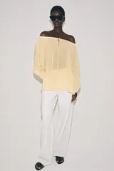 Blusa de lino color blanco, con escote recto ajustable mediante cordón y hombros descubiertos. Cuenta con manga larga abullonada terminada en elástico.