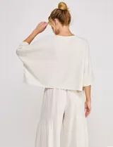 Blusa corta color beige de lino y viscosa, con escote redondo, mangas tres cuartos estilo kimono y corte holgado.