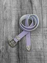 Cinto lila pastel con hebilla y aplique en la punta con diseño ornamentado color plateado.