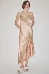 Vestido largo tipo lencero de Zara Woman Collection, confeccionado en tejido satinado color rosado con escote en pico y tirantes finos. Presenta detalles de aplicaciones de encaje a contraste y bajo asimétrico.
