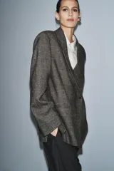 Blazer Zara Woman Collection confeccionada en tejido con lana, de corte oversize. Presenta cuello con solapas de muesca, cierre frontal cruzado con un botón y bolsillos de vivo en el delantero. Incluye forro interior.