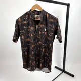 Camisa de algodón estampada en tonos marrón y tierra, con cuello mao y manga corta.