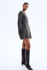 Vestido corto de punto acanalado con diseño entallado, cuello redondo, mangas largas y falda con leve vuelo.