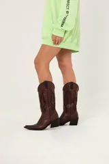 Bota texana marrón de cuero con bordados negros en el empeine y la caña.