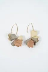 Aros colgantes con diseño de pétalos en color negro y azul oscuro, montados sobre un gancho de metal dorado.