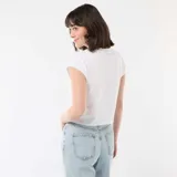 Remera corta blanca con diseño estampado de Stitch en el pecho y letras decorativas.