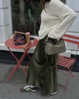 Pollera midi color verde oliva de seda, con cintura elástica.