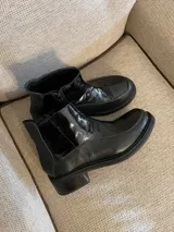 Botas cortas negras de cuero vacuno con elástico lateral y cierre.