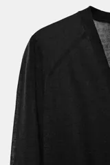 Chaqueta de punto semitransparente con escote en pico, manga larga y cierre frontal con botones. Presenta puños y cintura acanalados.