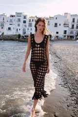 Vestido midi de crochet negro, sin mangas, con escote redondo y bajo terminado en flecos.