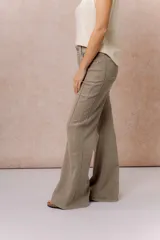 Pantalón de jean color arena con silueta wide leg, tiro medio-alto y costuras verticales delanteras que estilizan la figura. Cuenta con bolsillos funcionales y cierre frontal con doble botón.