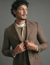 Saco sport de gamuza ecológica, con cierre de dos botones frontales, solapas clásicas y bolsillos laterales con solapa.