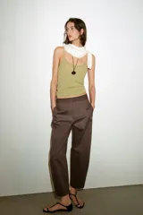 Pantalón de tiro medio con diseño barrel, pernera holgada que se estrecha hacia el tobillo, bolsillos delanteros y bolsillos de plastrón en la espalda. Confeccionado en tejido con textura de espiga, cuenta con cierre frontal de cremallera, botón interior y gancho.