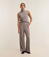 Pantalón wide leg de tiro alto color gris, confeccionado en chenilla con textura aterciopelada, cintura elástica con detalle de trabillas y costuras verticales decorativas en el frente.