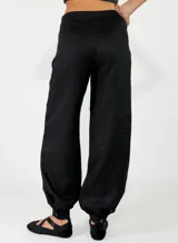Pantalón de lino color rojo, de corte holgado con botamangas elastizadas y diseño cruzado en la cintura con lazo ajustable.