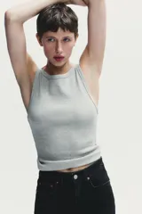 Jeans de mujer, tiro alto, color azul medio con efecto desgastado (lavado claro en muslos y oscuro en bordes). Corte recto y ancho (mom fit) con cinco bolsillos y cierre frontal de botón y cremallera.