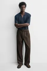 Mocasín destalonado de cuero color marrón topo con acabado serraje, antifaz en el empeine, horma redonda y suela a tono con ligero tacón.