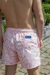 Short de baño rosado con estampado de margaritas blancas y amarillas, cintura elástica con cordón ajustable.