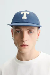 Camiseta gris de corte cuadrado y holgado, con cuello redondo y mangas cortas.