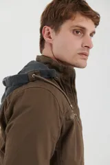 Campera técnica de tejido elástico en color azul marino, con capucha ajustable, cierre frontal y bolsillos laterales con cierre. Cuenta con forro interior de micro polar y ajuste en el ruedo.