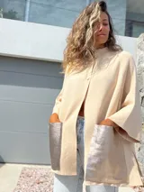 Saco tejido de punto en color crudo, con diseño holgado, mangas tres cuartos y bolsillos frontales grandes confeccionados en cuero metalizado plateado.
