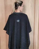 Ruana tejida en algodón con destellos de lurex, de corte amplio y diseño abierto, con textura en punto relieve.