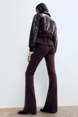 Pantalón ajustado de punto fino en color bordó, de tiro alto con elástico revestido en la cintura y diseño de piernas acampanadas.
