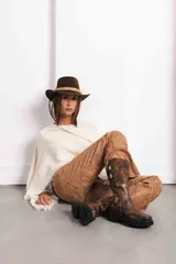 Bota de caña media-alta en cuero color óxido de acabado gastado, con hebillas de inspiración gótica y punta cuadrada bien marcada.