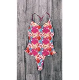 Malla enteriza con estampado de flores y hojas en tonos rosa, rojo, amarillo y celeste. Tiene breteles finos cruzados en la espalda y volados en la parte inferior.