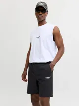 Bermuda deportiva negra de calce relajado, con cintura elástica ajustable mediante cordón, bolsillos laterales y costuras frontales en relieve. Presenta un pequeño estampado de texto en la pierna izquierda.