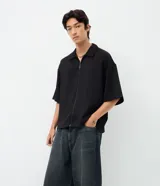 Pantalón jean de corte super baggy, color azul oscuro con efecto lavado, confeccionado en algodón. Presenta un diseño holgado de tiro alto, con bolsillos laterales y traseros, destacando un detalle de estrella aplicado en uno de los bolsillos posteriores.