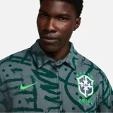 Chaqueta Nike estilo Harrington de la selección de Brasil, color gris con estampado gráfico en verde oscuro. Cuenta con cierre completo, cuello italiano, bolsillos en ángulo y dobladillo parcialmente elástico.