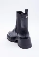 Bota marrón de símil cuero, con punta redondeada, pieza elastizada negra en los laterales y plataforma de 6cm.