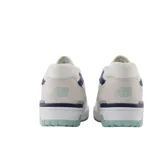 Championes urbanos New Balance modelo 550, con diseño retro inspirado en el básquet. Presentan una base de cuero blanco con perforaciones laterales, detalles en azul petróleo, gris y violeta en el talón y la suela. Incluyen el logo N característico en los laterales y el número 550 en el frente.