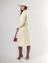 Tapado de paño sofisticado con solapas clásicas, cierre frontal de botones y bolsillos laterales. Presenta un diseño de corte recto y estructura elegante.