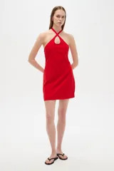 Vestido corto rojo con escote halter cruzado y detalle de abertura en el pecho, corte al cuerpo y cierre posterior.