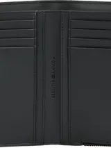 Billetera plegable color negro de Tommy Hilfiger, con acabado granulado, cierre de botón a presión, bolsillo exterior con cremallera e insignia metálica del monograma TH en la parte delantera.