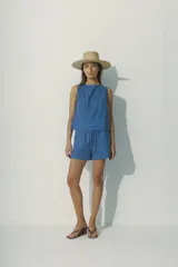 Short de tela a rayas verticales en tonos marrón, negro y blanco, con cintura elástica y cordón ajustable.