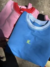 Buzo deportivo de color azul claro, estilo oversize, con cuello redondo y puños y ruedo con elástico. Presenta un pequeño logo bordado en el pecho.