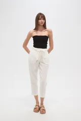 Pantalón de algodón color beige, de corte recto y tiro medio, con cintura elástica y lazo ajustable del mismo tejido.