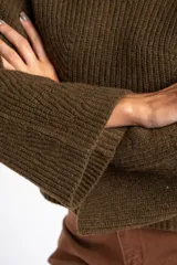 Sweater de punto acanalado color marrón, con cuello alto tipo polera y mangas largas de corte ancho. Posee un diseño oversize confeccionado en mezcla de lana.