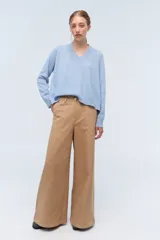 Sweater de tejido de punto color beige, con escote en V y calce holgado.