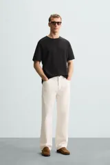 Remera color arena de corte recto, cuello redondo y mangas cortas.