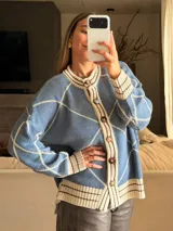 Saco tejido de algodón con lurex, diseño de rombos en color azul y beige, con cuello redondo, cierre frontal de botones y mangas abullonadas.